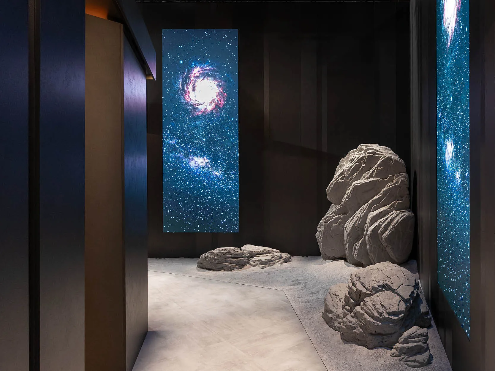 CLEAF 展間一隅展示仿太空地貌的石材與天幕星空投影，營造宇宙與自然融合的情境體驗。