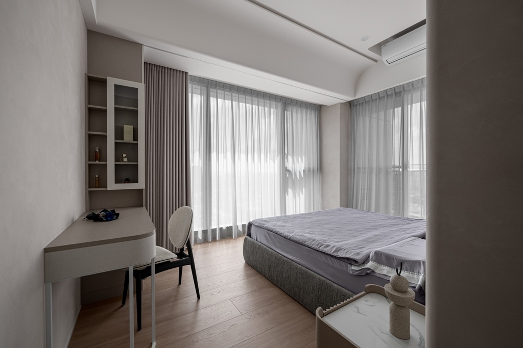 臥室採用 EGGER 系統櫃與書桌結合設計，搭配落地窗與輕柔窗簾，引入自然光線，塑造溫馨舒適的休憩空間。