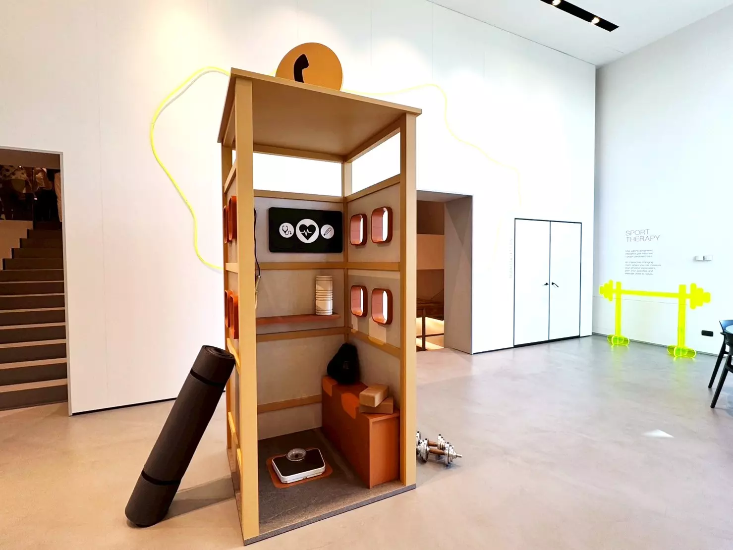 CLEAF 展示空間中的創意電話亭造型裝置，結合木質結構與多項展示配件，呈現品牌材料在趣味與功能並存的應用情境。