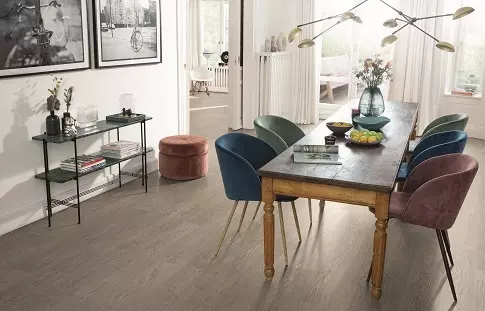 傳統餐廳風格，搭配原木桌與多彩椅子，深色木地板鋪設，周圍擺設藝術畫與家飾品。