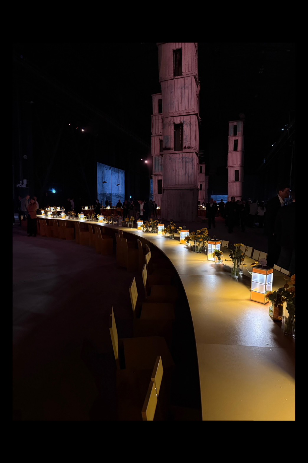 CLEAF 沉浸式展覽現場，長桌設有照明裝置與展示物，背景塔型裝置與昏暗氛圍營造出劇場式空間感。