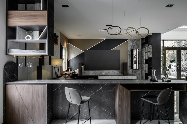 開放式吧台設計選用 EGGER 板材與深色塑合板，與客廳相互呼應，展現石紋與木質的自然融合，結合功能性櫃體，打造實用與設計兼具的現代餐飲空間。