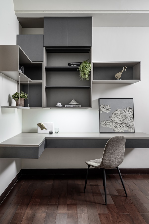 簡約書房設計以淺灰色 EGGER 板材規劃牆面與層架，塑合板材質表面耐刮耐用，搭配開放收納櫃與工作桌，呈現清爽乾淨的閱讀與辦公氛圍。