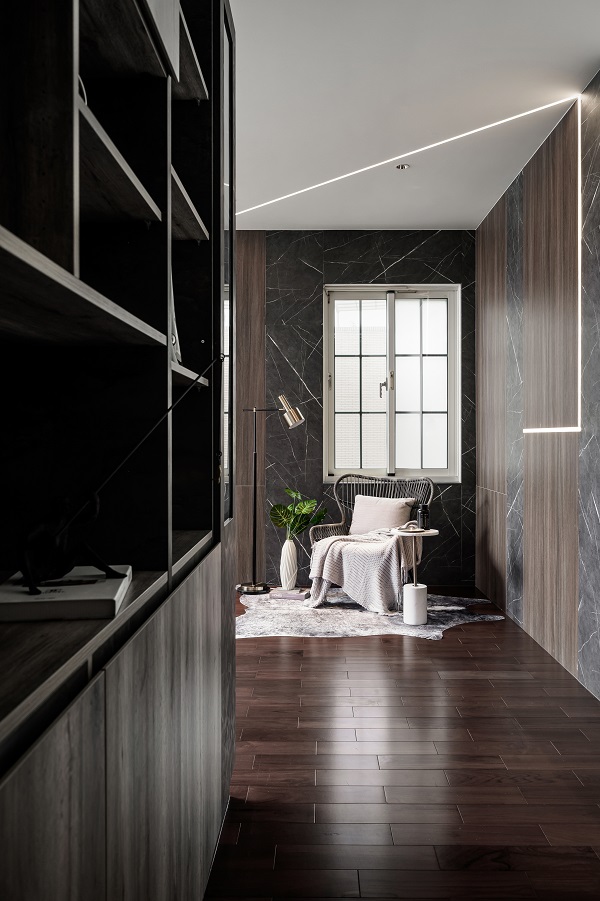 過道空間牆面採用木紋與深色 EGGER 塑合板相結合，搭配現代光帶設計，營造時尚高級感，同時保持功能性收納與溫潤居家氛圍。