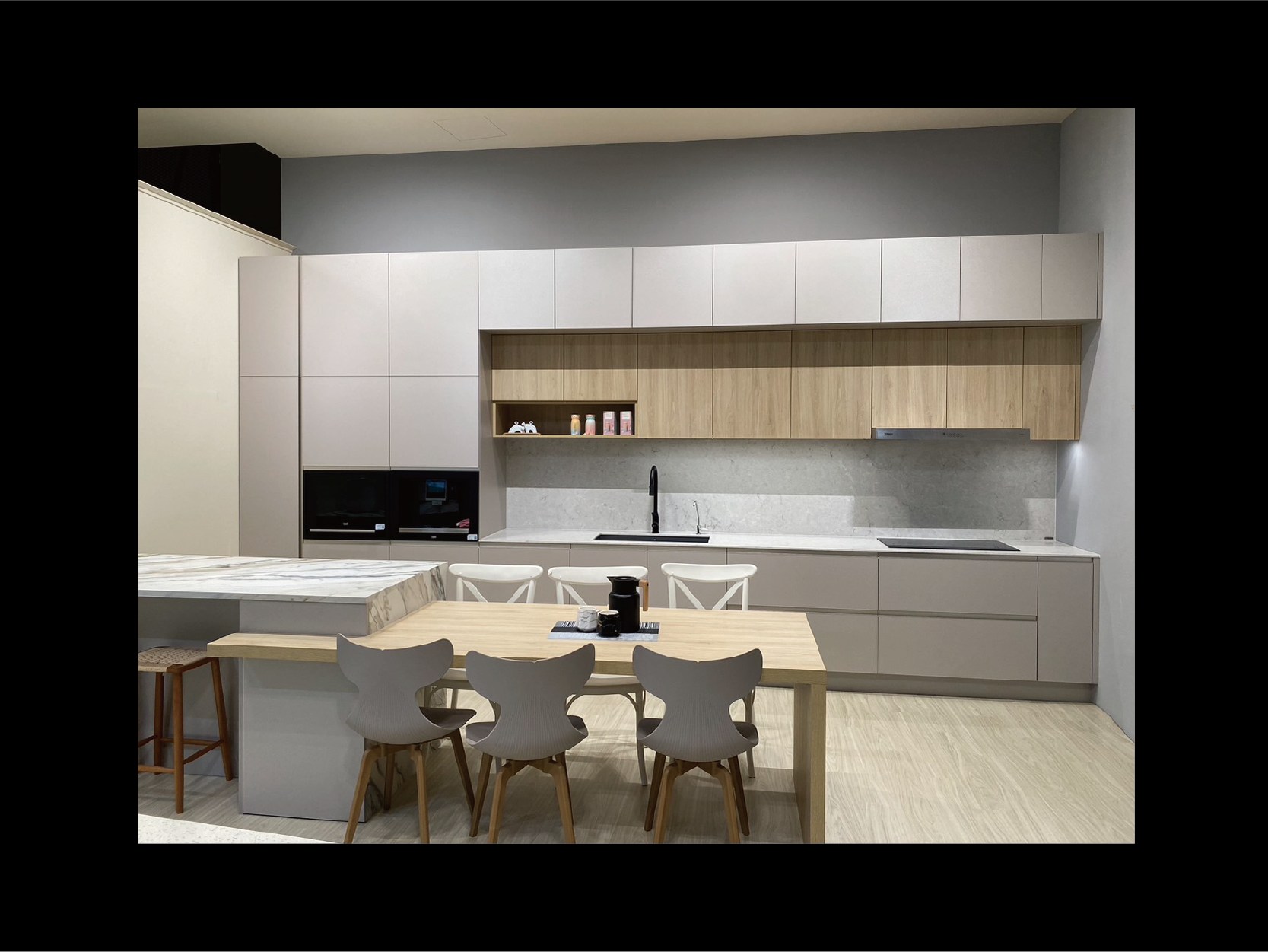 整體空間採用 CLEAF 板材櫥櫃，結合白色與木紋對比，搭配餐桌與吊燈設計，呈現開放式廚房的現代感。