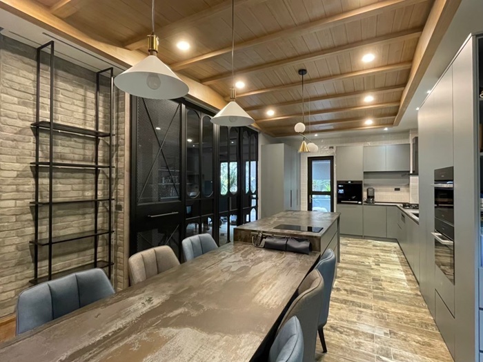 木質天花板、黑色金屬隔間與石紋餐桌相結合，呈現 EGGER 材質與現代工業風格的完美融合，適合開放式住宅設計。