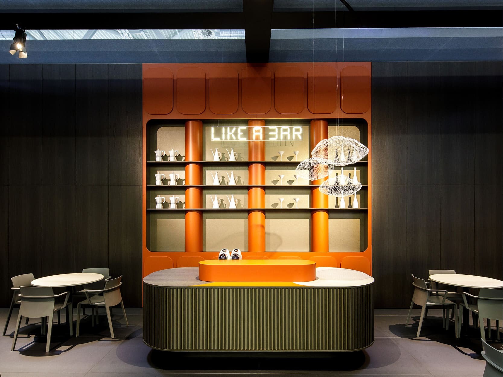 CLEAF 展區設計以『LIKE A BAR』為主題，使用橘色櫃體與白色燈飾，打造如精品咖啡吧檯般的空間氛圍。