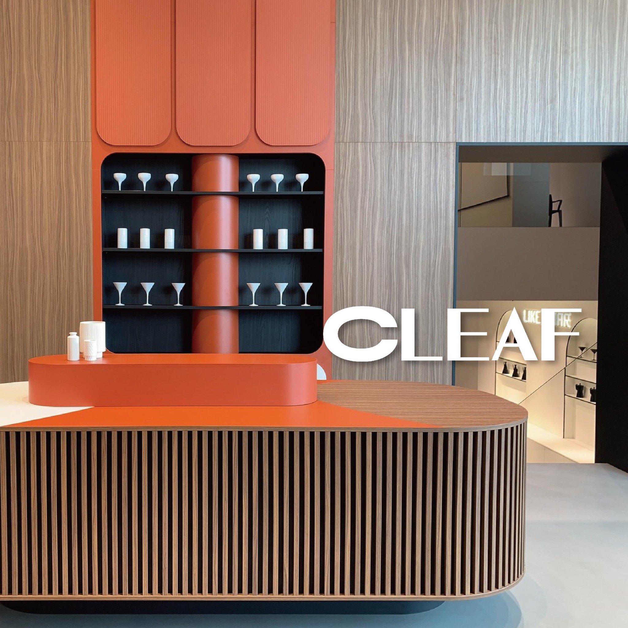 CLEAF 展間以圓弧形櫃體與橘紅色與木紋搭配為主題，展現品牌材質應用於空間美學中的創新風格。